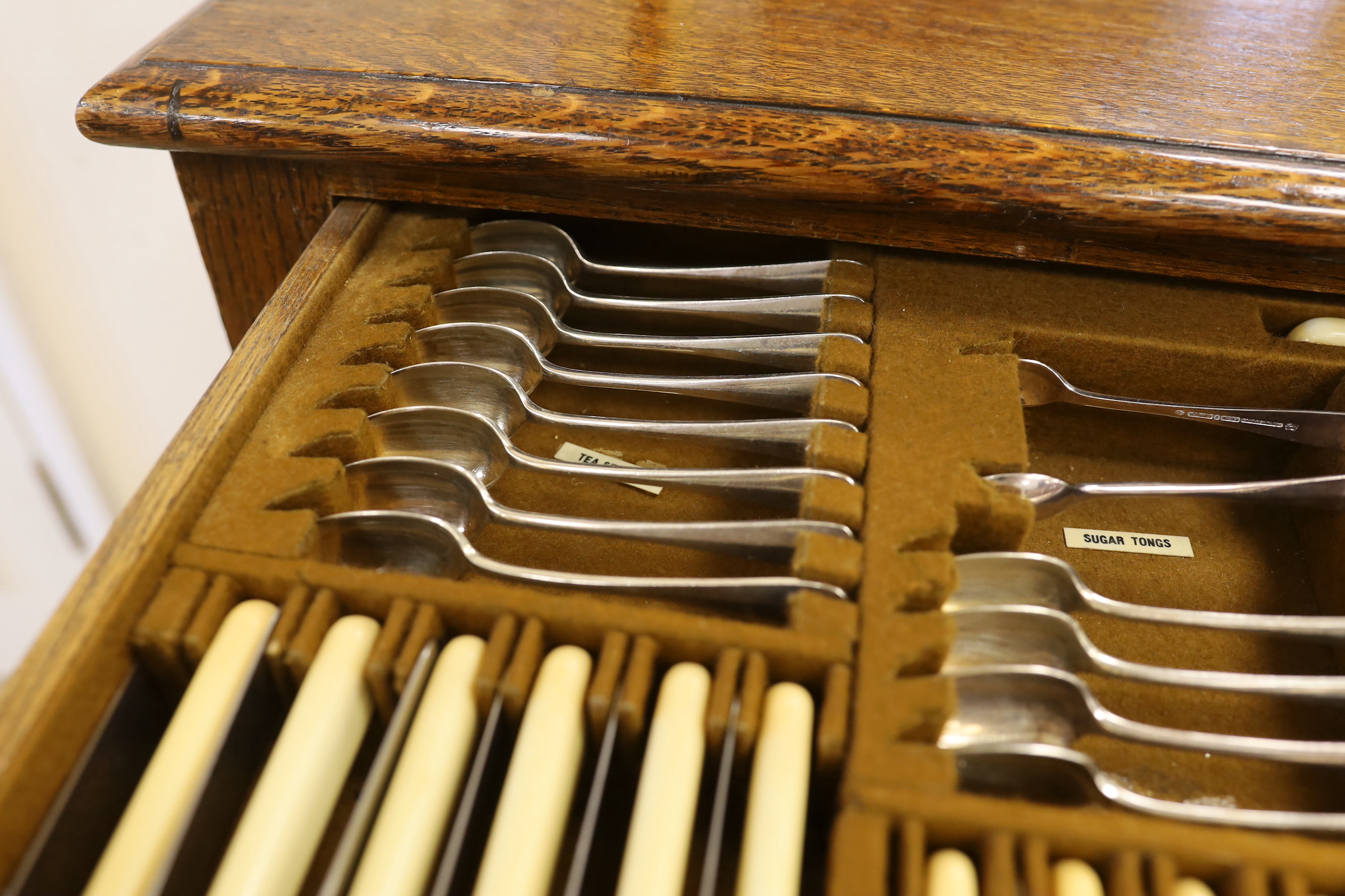 An oak standing canteen with two drawers of Mappin and Webb silver plated cutlery, settings for twelve people, 78cm high x 70cm wide x 54cm deep